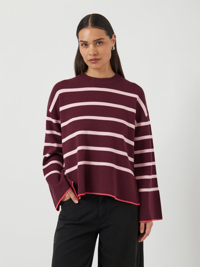 Maglione a righe bordeaux e rosa con una texture a coste, maniche ampie e aperture laterali. Presenta un colletto tondo e un dettaglio rosa all'orlo.