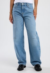 Lichtblauwe, wijdvallende jeans van denim met een middelhoge taille. Beschikt over een vijf-pocket ontwerp en minimale stiksels.