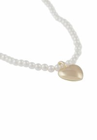 Rad av vita pärlor med en slät gul hjärtformad berlock fäst.