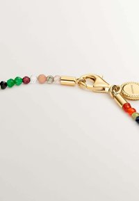 Cadena de cuentas con cuentas de vidrio redondas y faceteadas de varios colores, terminada con un cierre de langosta en tono dorado y una etiqueta circular.