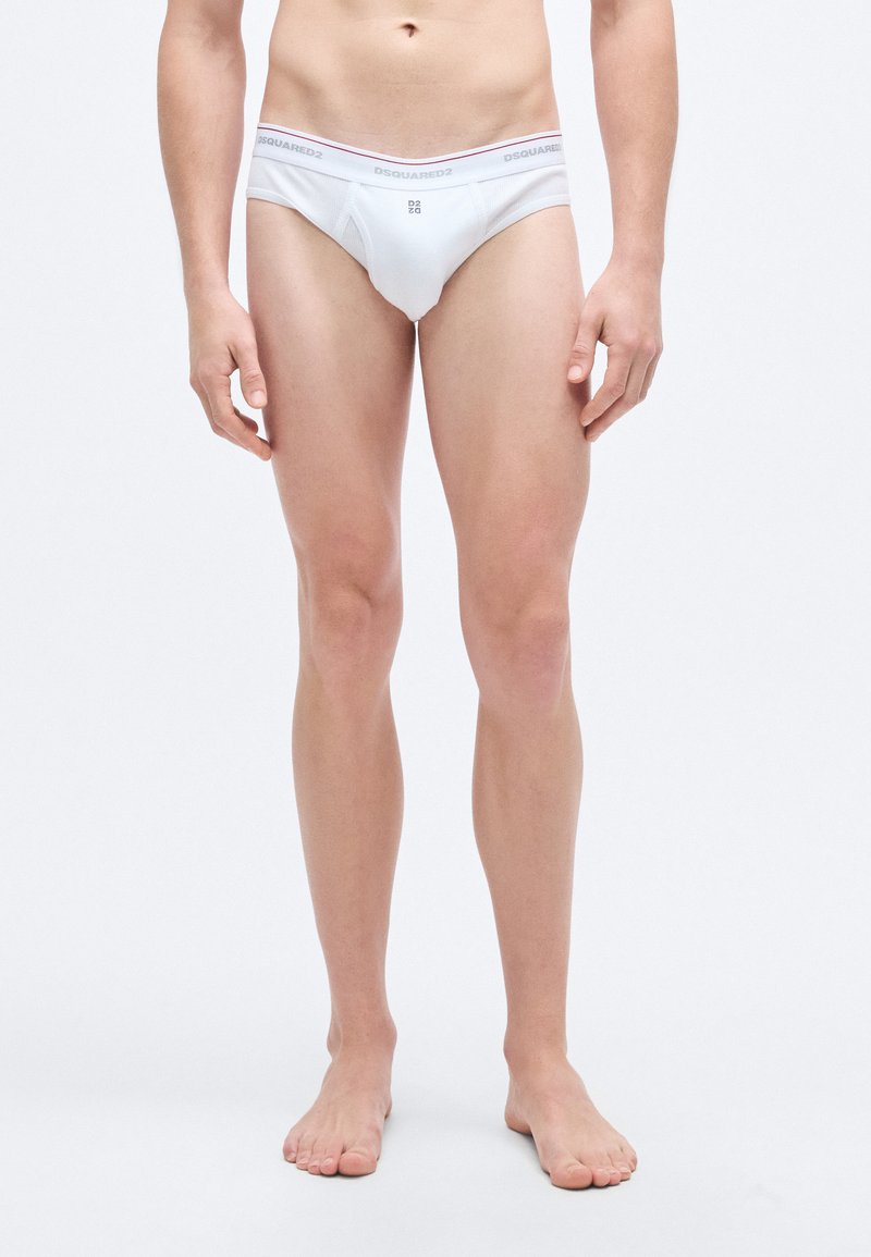 Άσπρα βαμβακερά εσώρουχα με στενό ζωνάρι που φέρει γκρι και ροζ κείμενο. Η εφαρμογή είναι στενή, με απλό, μίνιμαλ σχέδιο.