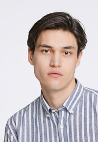 Geknoopte overhemd met een kraag, voorzien van verticale blauw-witte strepen, met een getextureerde stof en zichtbare knopen op de kraag.