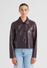 Kurze, taillierte Jacke aus dunkelviolettem Leder mit spitzem Kragen, vorderen Knöpfen und zwei Vorderaschen. Glatte Textur, figurbetontes Design.