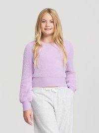 Jasnofioletowy skrócony sweter wykonany z puszystego materiału z prążkowanymi ściągaczami. Połączony z szarymi spodniami dresowymi z regulowanym pasem na sznurek.