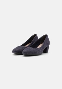 Violet velūra zema papēža kurpes ar norādītu purngalu un gludu tekstūru, piedāvājot elegantu dizainu un ērtu piegulšanu.