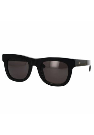 Occhiali da sole neri con montatura squadrata, lenti scure e finitura lucida. Presenta un logo laterale in oro. Design minimalista, forma angolare.