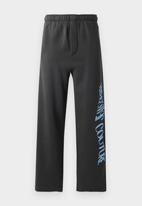 Black sweatpants made of soft fabric, featuring a loose fit and an elastic waistband. Notable blue printed text along the side.