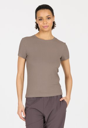 Bruine geribbelde t-shirt met korte mouwen en een ronde hals, gecombineerd met donkergrijze broek. Het shirt heeft een getailleerde pasvorm en een gladde textuur.