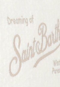 Texte brodé beige sur un tissu blanc texturé, avec la phrase « Rêver de Saint Barth » et « Paradis d'hiver » en dessous.