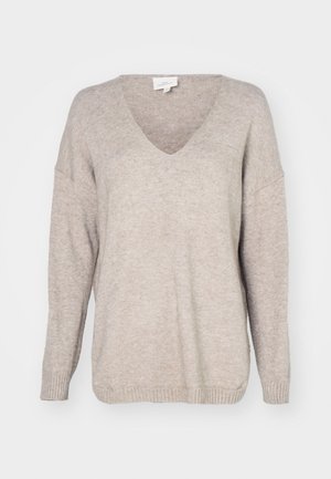 Pulôver bege em formato de v, feito de um material de malha suave, com um corte descontraído, ombros deslocados e punhos e barra canelados.