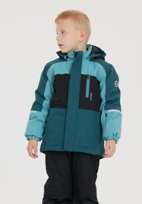 Kinderjacke in Türkis und Schwarz mit Reißverschlusstaschen, Kapuze und elastischen Bündchen. Hergestellt aus wetterfestem Material.