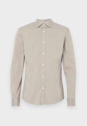 Camisa de manga longa em algodão cinza-claro com colarinho pontudo, fecho frontal com botões e mangas com punhos. Textura suave e design ajustado.