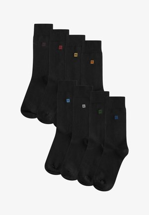 Fekete zoknik sima felülettel, kicsi színes „N” logókkal piros, sárga, kék, szürke és zöld színben a szárán. Nyolc párból álló szett.