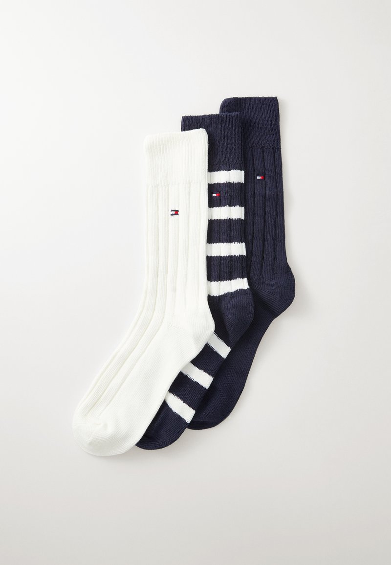 Three pairs of cotton socks: one solid white, one solid navy, and one navy with white stripes. Each features a small logo on the leg.