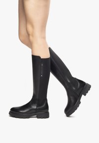 Knöchelhohe schwarze Stiefel mit Lederfinish, strukturiertem Nylonpaneel, runder Zehenpartie und robuster Gummisohle mit leichtem Profil.