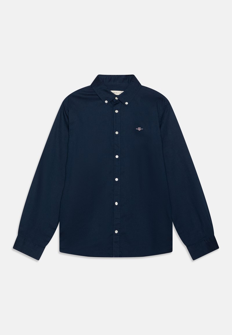 Granatowa koszula zapinana na guziki z długim rękawem, z kołnierzykiem i białymi guzikami; posiada małe logo na lewej piersi. Wykonana z materiału bawełnianego, o gładkiej fakturze.