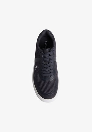 Čierna teniska Calvin Klein s vrchnou časťou z textílie s okami, šnurovačkou vpredu, bielou gumovou podrážkou a značkovým logom „ck“ na boku, pohľad zhora.