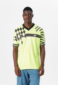 Lime zöld sportmez fekete sakktáblás és csíkozott mintázattal, v-kivágással, fehér "3"-as számmal és Adidas logóval a mellkason.