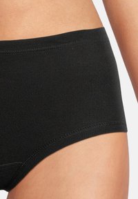 Slip neri in cotone con una consistenza morbida e liscia. Presentano un ampio elastico in vita e un design semplice e senza cuciture per il massimo comfort.