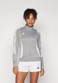 Gray zip-up athletic jacket with white accents and three white stripes on each sleeve. Soft fabric and fitted design.