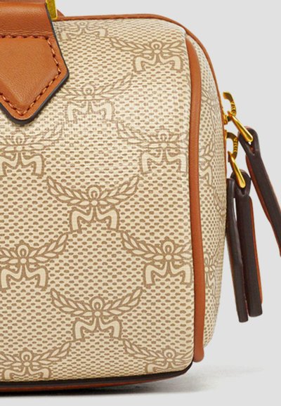 Beige texturerad handväska med bruna detaljer, med ett vävt mönster och präglad design. Inkluderar ett överhandtag och avtagbar rem.