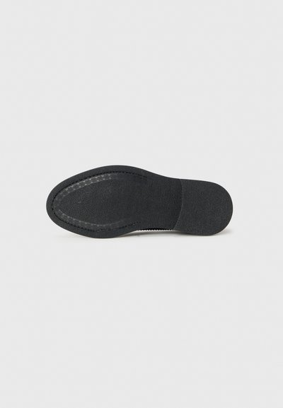 Schwarze Schuhsohle mit strukturiertem Gummioberfläche, mit einer glatten Ferse und genähten Randdetails. Flaches und leicht konturiertes Design.