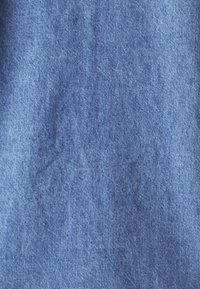Gros plan d'un tissu en denim bleu montrant la texture et le motif de tissage.