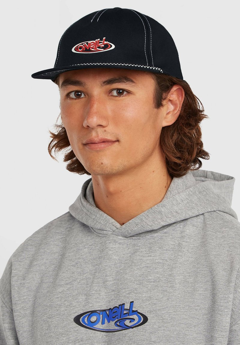 Casquette noire avec surpiqûres blanches et logo O'Neill rouge sur le devant, portée avec un sweat à capuche gris arborant un logo bleu.