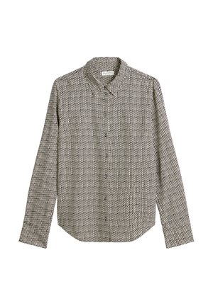 Chemise à manches longues noire et blanche à motifs, avec un col pointu et un bouton sur le devant, présentant des formes géométriques et une texture de tissu lisse.