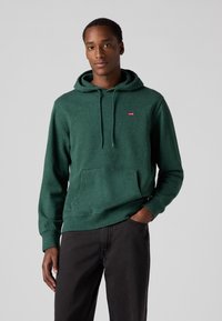 Groene textuur hoodie met een kangoeroezak en verstelbare trekkoord, met een klein rood Levi's logo op de bovenste linkerborst.
