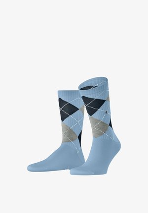 Hellblaue Socken mit einem Rautenmuster in Marineblau, Grau und Hellgrau, mit kontrastierenden weißen Nähten entlang der Rautenkanten.