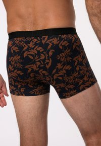 Černé boxerky s hnědým květinovým vzorem. Vyrobené z měkké tkaniny, s černým pasem, na kterém je vyraženo "JP1880".