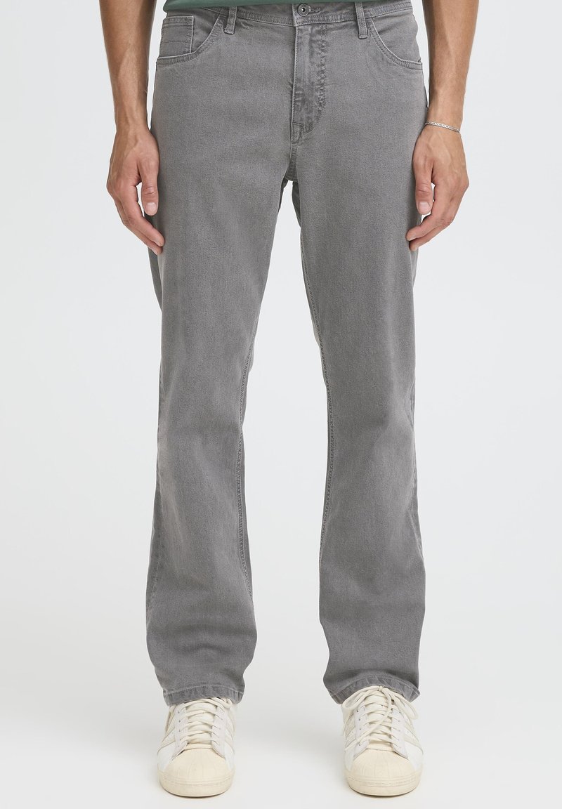 Jeans di denim grigio con vestibilità a gamba dritta, design a cinque tasche e sfumature discrete. Abbinati a sneakers color avorio.