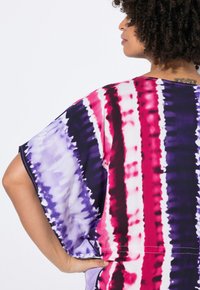 Bunt gestreiftes Oversize-Oberteil mit einem Batikmuster in den Farben Pink, Lila und Weiß. Kurzärmeliger und lockerer Schnitt.
