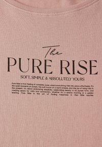 Světlé růžové látky s výrazným černým textem. Horní řádek zní "The PURE RISE", následovaný popisným textem níže v menším písmu.