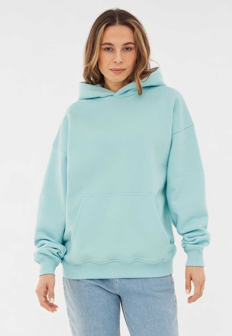 Felpa oversized azzurro chiaro realizzata in tessuto morbido, con tasca a marsupio, polsini a costine e orlo arrotondato.