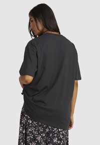 Grijze katoenen T-shirt met een relaxte fit, korte mouwen en een ronde halslijn, gecombineerd met een rok met bloemmotief.