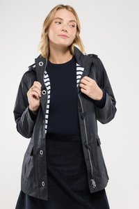 Giacca da pioggia nera resistente all'acqua con cappuccio, chiusura con cerniera e hardware argentato. Presenta una fodera a righe e cordini regolabili.