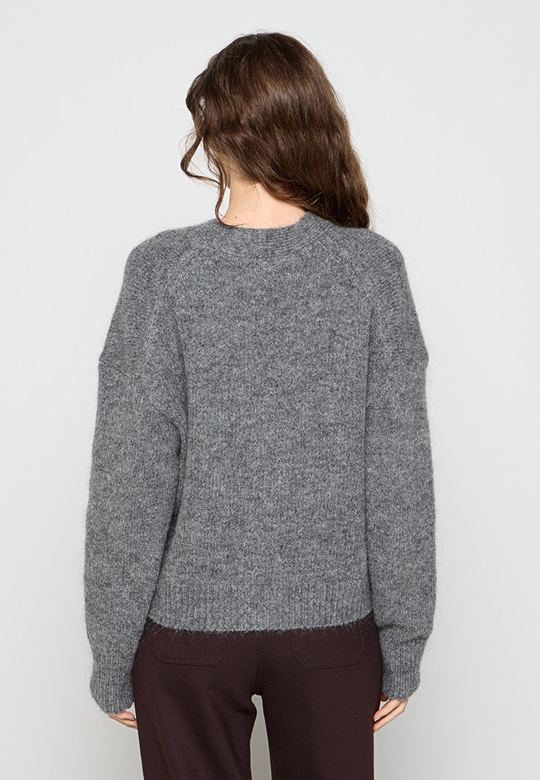 Grau strukturierter Pullover mit Rundhalsausschnitt, überschnittenen Schultern und geripptem Saum. Aus einem weichen, flauschigen Material gefertigt.