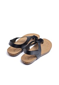 Sandales noires avec semelle en liège, sangle réglable et semelle texturée. Présente un design minimaliste avec une finition lisse.