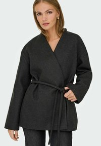 Wickeljacke aus dunkelgrauem Wollgemisch mit tiefem V-Ausschnitt, weiten Ärmeln und einem gebundenen Gürtel in der Taille. Strukturierter, minimalistischer Stil.