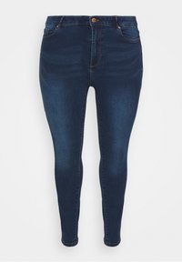 Dunkelblaue Skinny-Jeans aus Denim mit einer vorderen Knopfverschluss, fünf Taschen und dezentem Ausbleichen entlang der Oberschenkel.