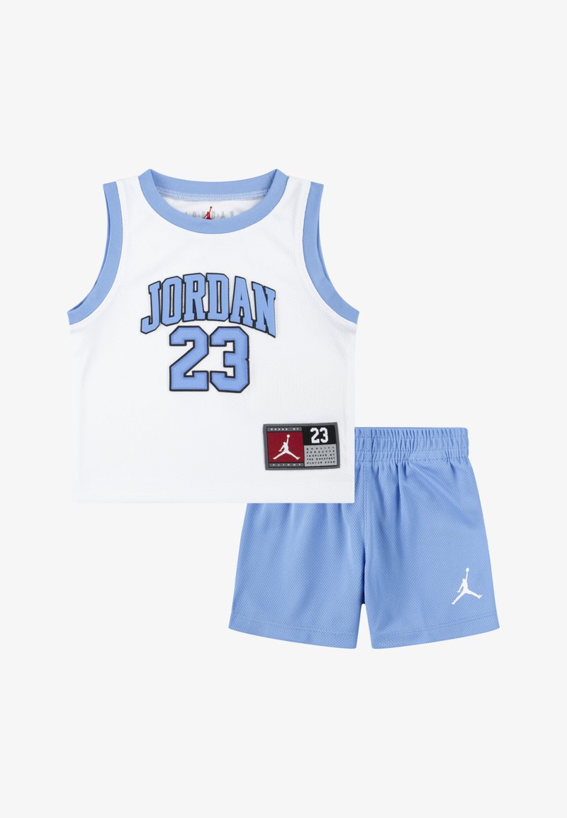 Camiseta de baloncesto de malla blanca con ribete azul claro, con "JORDAN" y el número "23" en azul, y una etiqueta. Combinada con pantalones cortos azul claro.