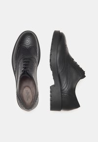 Zwarte leren schoenen met brogue-details, ronde neus en robuuste rubberen zool met een gestructureerde afwerking. Klassiek vetersluiting ontwerp.