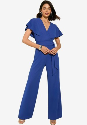 Combinaison bleu royal avec des manches courtes en volant, un décolleté en V et une taille ceinturée. Design à jambes larges avec une texture lisse et des accents minimalistes.