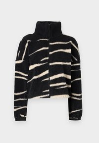 Czarna polarowa kurtka z białymi, abstrakcyjnymi paskami przypominającymi zebrę, z wysokim żebrowanym kołnierzem, pełnym zamek błyskawicznym z przodu oraz długimi rękawami.