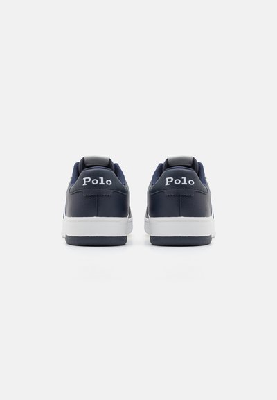 Zapatillas de cuero azul marino con suelas blancas, que presentan un collar y una lengüeta acolchados. Logo "Polo" visible en la parte posterior, con costuras en contraste.