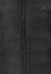 Sort puffervest med lynlås foran, der har en quiltet tekstur og glat materiale. Accentueret med et subtilt logo nær den øverste venstre side.