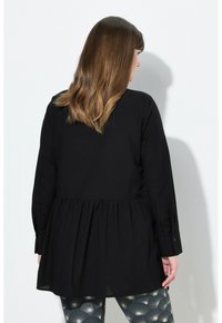 Černý dlouhý rukáv top s volným střihem a peplum detailem v pase. Vyrobeno z hladké tkaniny, má knoflíkové manžety a kulatý výstřih.
