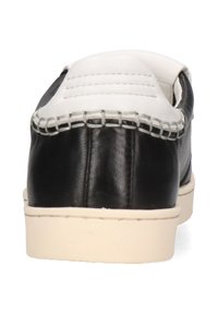 Scarpa in pelle nera con accenti bianchi, dotata di dettagli cuciti e punta arrotondata, montata su una suola in gomma beige.